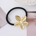 Dettaglio macro di elastico per capelli con fiore dorato e perla bianca centrale - Stile Fiore Oro 5