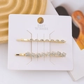 Detailed macro view of two-piece golden hair clips with rhinestones and faux pearls - 2PCS / Combination 2