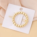 Detailed macro view of a minimalist golden circular hair clip with twisted metal texture - Twisted Rope Circle