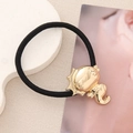 Détail d'une breloque hippocampe dorée sur un élastique à cheveux noir haute élasticité - Hippocampe Rond