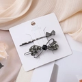 Detailaufnahme von Schleifen-Haarspangen mit dunkelgrauen und schwarzen Strasssteinen - Dunkelgrau Schwarz Großer Strass Stil / Schwarzes Schleifen-Outfit