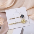 Detail of two-piece clover hair clips with POPULAR text and rhinestones on card - Gold Clover Set