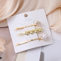 Three-piece gold hair clip set with clover, heart and pearl designs on a display card - Gold Flower Jewelry Set