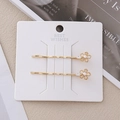 Dettaglio di fermagli per capelli a fiore dorato con perle finte e strass scintillanti - Stile Perla e Fiore d'Oro
