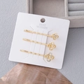 Elegantes 3er-Set goldene Haarklammern mit geometrischen Knoten und Strass auf weißer Karte - Komplettes Sortiment