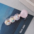 Close-up of glittery pink shell and iridescent petals with a pearl on a sweet hair clip - Pink Pearl Shell Style A