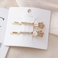 Détail de barrettes dorées avec fleurs blanches et cristaux de strass champagne - Café Floral