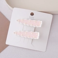 Close-up of pink polka dot hair clips with wave edges on a display card for styling - Pink Wave