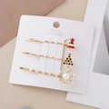 Tre fermagli natalizi dorati con albero smaltato e fiocco perlato su carta decorativa - Combo di Natale 2 (Albero Fiocco)