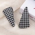 Close-up of black and white houndstooth tweed triangle hair clips on beige linen background - Black Triangle