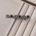 Detail of vintage flower hair clip with black and grey crystals on a metal duckbill base - Six Round Grey-Black Crystal Style