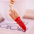 Exquisite gold-plated lipstick keychain with red rhinestones and hollow mesh design - Red