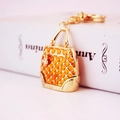 Orange enamel purse keychain with gold finish and rhinestone charm on a book - Gold