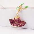 Creative gold hat keychain with pink rhinestones and pearl details on white box - Fuschia