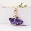 Golden sun hat keychain with deep blue rhinestones on a minimalist white display - Dark Blue