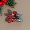 Detail of star-shaped Christmas hair claw with red and green gradient and snowflake pattern - Star
