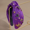 Detail of purple knotted carnival headband with colorful rhinestones and festive metal charms - Purple