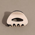 Detail view of the black and cream acetate hair claw with minimalist hollow design - Cream White Black