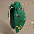 Detail of green Mardi Gras headband with purple fleur-de-lis and rhinestones - Green