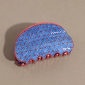 Dettaglio della pinza per capelli blu in denim con pois rossi e finitura lucida - Semicerchio