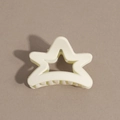 Close-up of cream star-shaped hair claw clip with matte finish and secure grip teeth - Pentagram / Off White