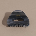 Detailed macro view of acetate hair claw clip with grey marble texture and gold lettering - Dark Gray