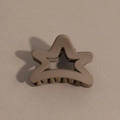 Detailed macro view of matte coffee brown star shaped hair claw clip on brown paper - Pentagram / Khaki