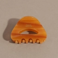 Macro detail of amber acetate hair claw clip with golden France Handmade logo lettering - Amber