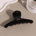 Detail of glossy black acetate hair claw with gold France Handmade logo text - Black