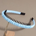 Detail of light blue woven headband showing inner non-slip teeth and satin fabric texture - Blue