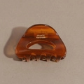Detail view of amber acetate hair claw clip showing gold France Handmade engraving - Transparent Brown