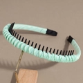 Detail view of the mint green satin headband featuring anti-slip inner plastic teeth - Green
