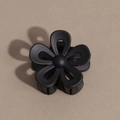 Detail view of a matte black flower hair claw clip with a five-petal hollowed design - Flower / Black