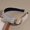 Detail of grey knitted wool headband featuring an amber resin oval buckle embellishment - Gray