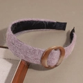 Close-up of pink knit headband with fluffy texture and brown marble ring detail - Purple