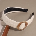 Detail of off-white knitted headband showing fuzzy texture and amber resin ring - Beige