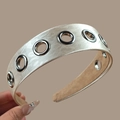 Dettaglio del cerchietto in raso oro champagne con occhielli in metallo e fodera antiscivolo - Beige