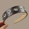 Macro shot of wide headband showing leopard texture and metallic silver eyelet detail - Gray