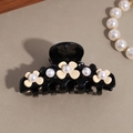 Détail d'une pince à cheveux élégante ornée de fleurs en résine et de perles blanches - Petite Fleur Noire