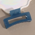 Detail of square navy blue glossy hair claw clip on a stylish decorative tray - Blue