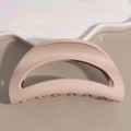 Detailed view of matte beige shark hair claw clip on an aesthetic pearl ceramic tray - Beige