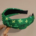 Detail of St. Patrick's Day green knotted headband with shamrock clover pattern print - Green Background Yellow Shamrock