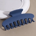 Detail view of navy blue matte hair claw clip on decorative white plate with smooth texture - Navy Blue