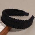 Dettaglio del cerchietto in maglia nera con bordi ondulati e finitura intrecciata a mano - Nero