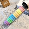 Regenbogenfarbene, elastische, nahtlose Haargummis in einer transparenten Röhre - Helles Mehrfarbig