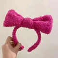 Detailaufnahme von flauschigem rosenrotem Plüsch-Haarreif mit großer Schleife aus Fleece - Rosarot
