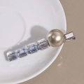 Macro view of hair clip with crystal beads and large champagne pearl on a ceramic plate - Silver