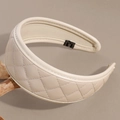 Close-up of cream faux leather headband featuring classic quilted diamond stitching texture - Beige