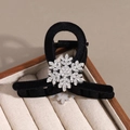 Gros plan d'une pince à cheveux en velours noir ornée d'un flocon de neige en strass - Noir