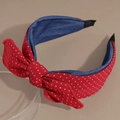 Detailopname van rode polkadots haarband met blauwe denim voering op een standaard - Rood met stippen